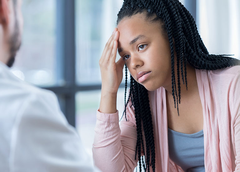 adolescente escucha el tratamiento de la migraña del médico